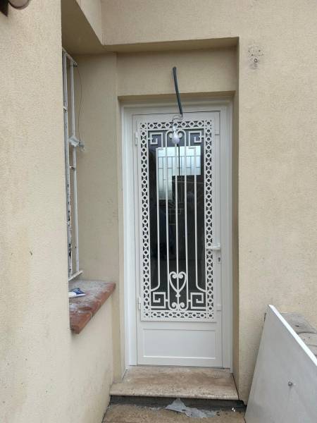 Porte aluminium avec grille décorative sur mesure fabriquée et posée par Azur Alu
