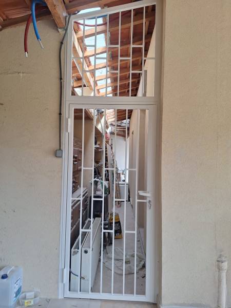 Porte avec grille de défense design sur mesure fabriquée et posée par Azur Alu